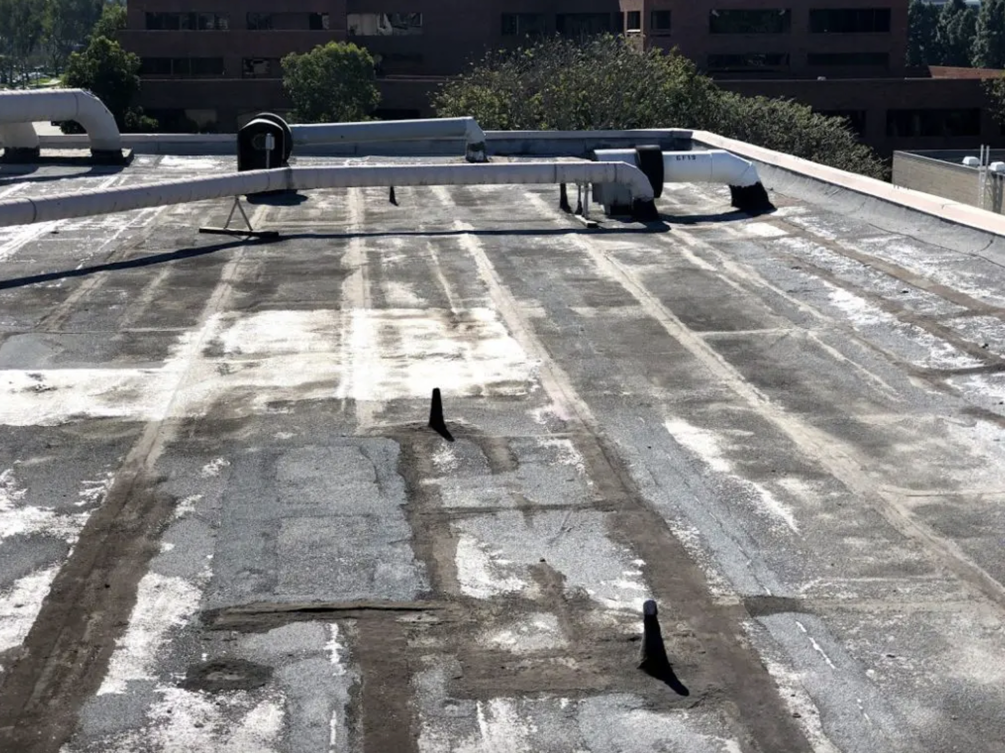 Deteriorated flat roof with patches and worn seams
